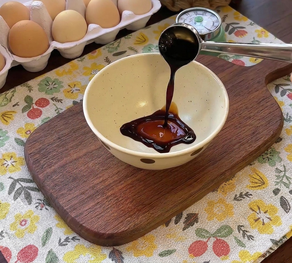 Ciemny sos wlewany do miski z innymi przyprawami do steku z hamburgera.