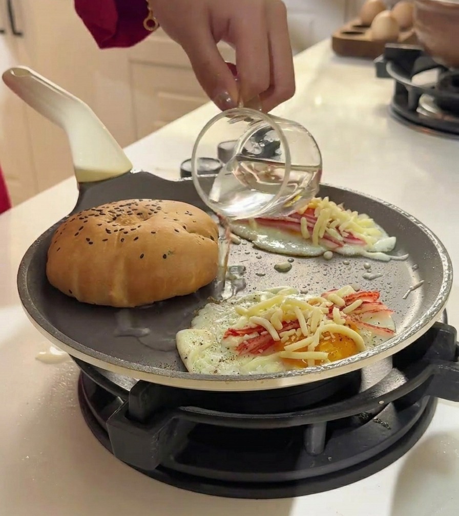 Wlewanie wody ze szklanki na patelnię obok burgera w celu wytworzenia pary.