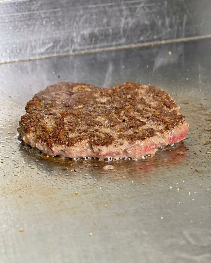 Usmażony kotlet z ciemnobrązową, chrupiącą skórką po odwróceniu.
