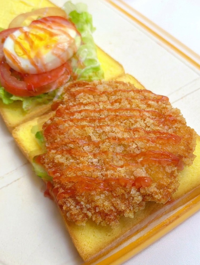 Chrupiący filet z kurczaka na toście polewany czerwonym keczupem.