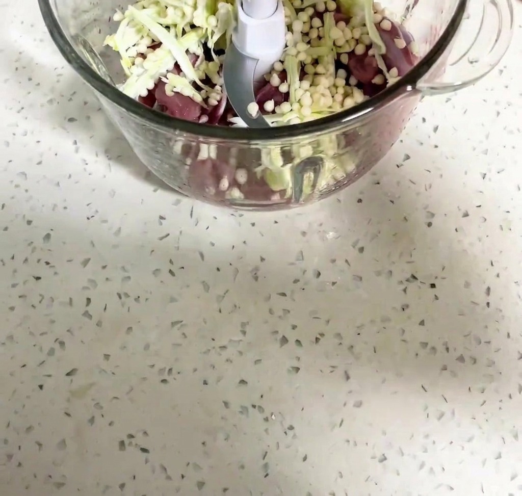 Mięso z kaczki i nasiona okry blendowane w misie robota kuchennego.