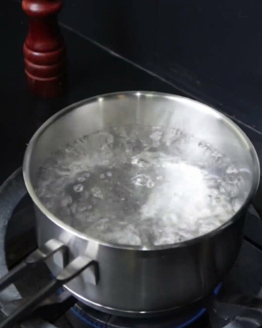 Nitki spaghetti wkładane do wrzącej osolonej wody.