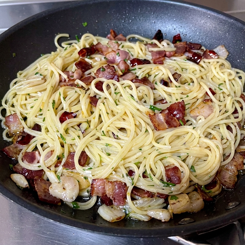 Świeżo posiekana natka pietruszki posypywana na wykończone spaghetti.