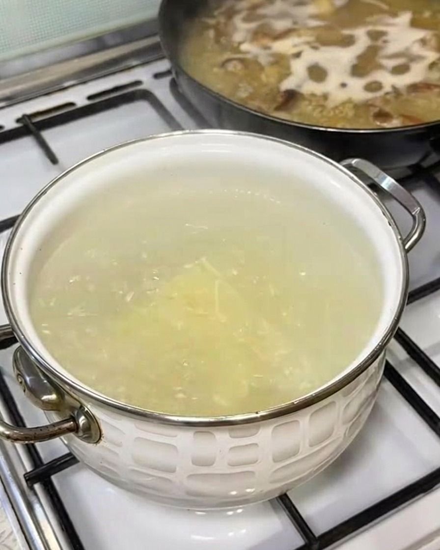 Porcja świeżego makaronu ramen wkładana do wrzątku.