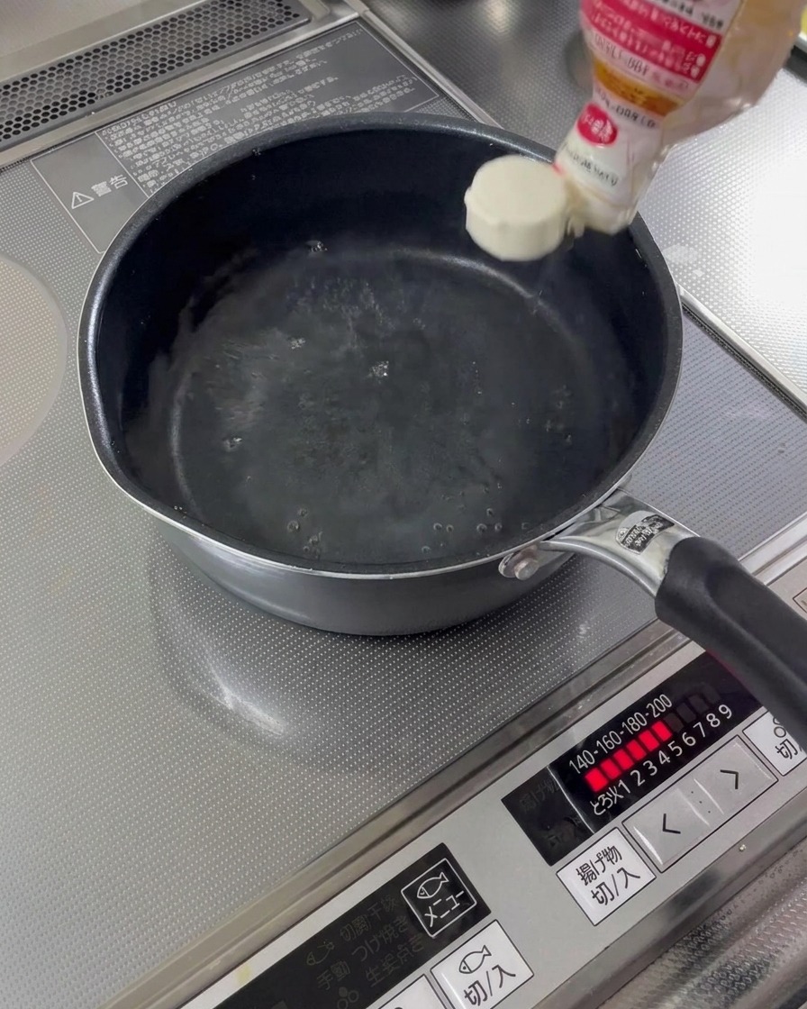 Sake do gotowania i mirin wlewane do rondelka z wodą.
