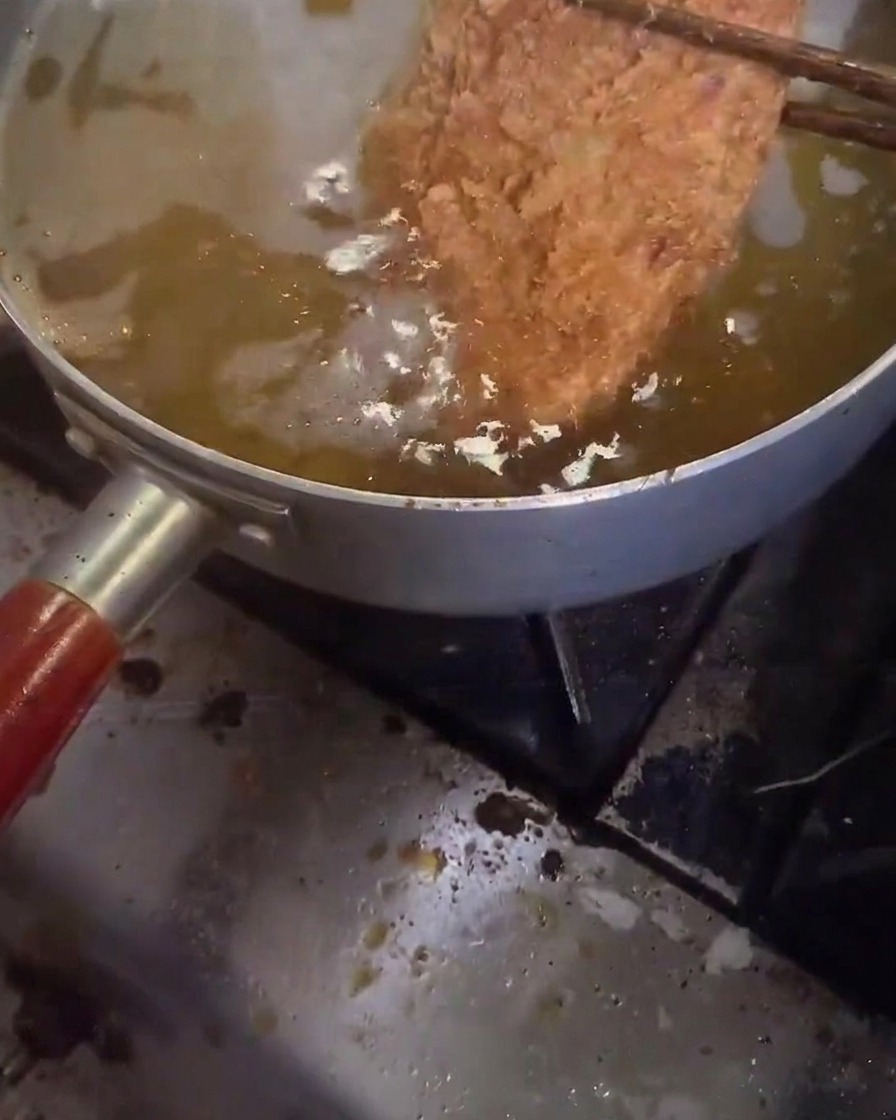 Kotlet wieprzowy smażony po raz drugi w gorącym oleju.