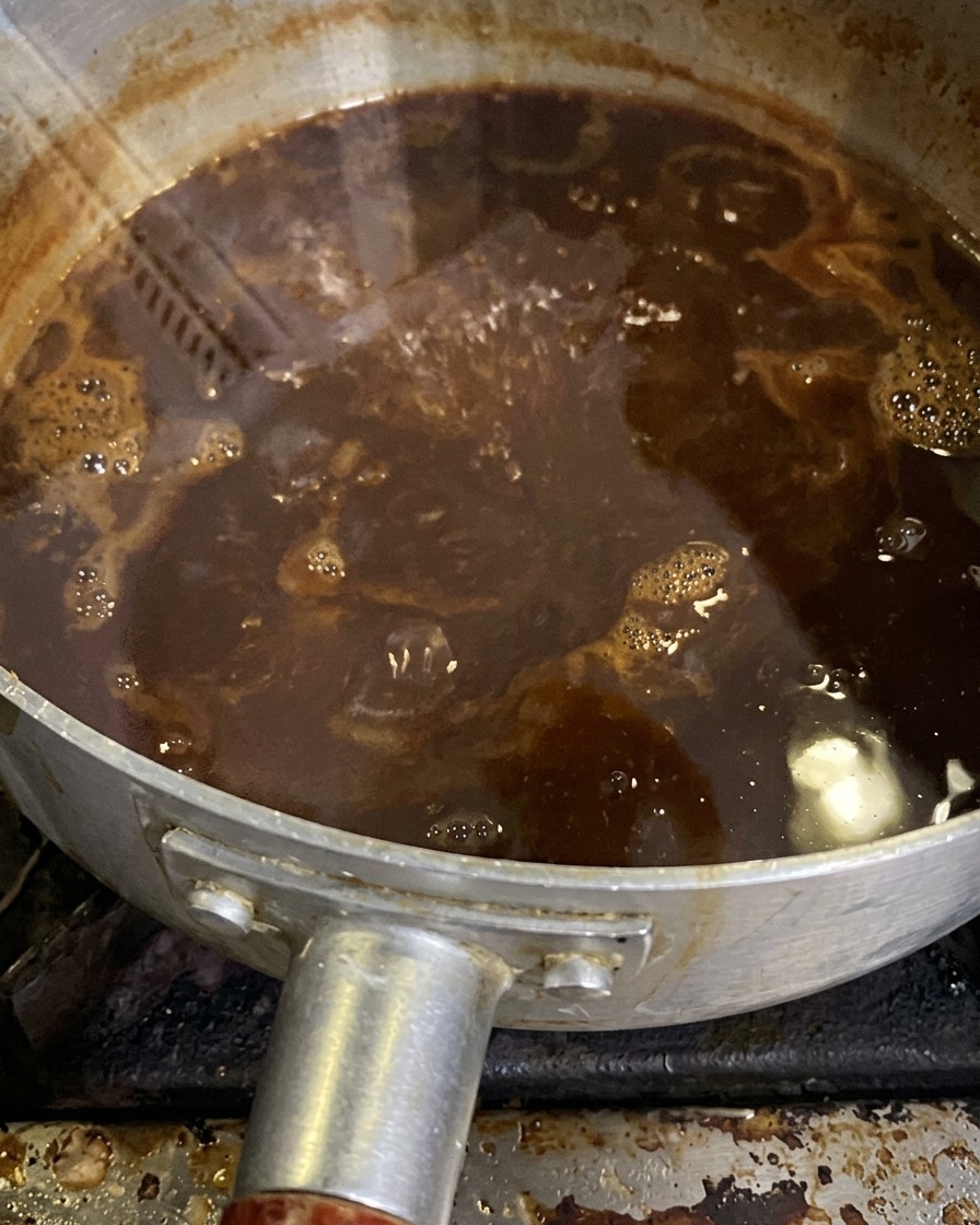 Sos miso delikatnie gotujący się i redukujący w rondelku.