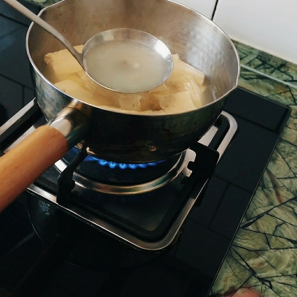 Kawałki curry rozpuszczane w chochelce zanurzonej w gorącej wodzie.