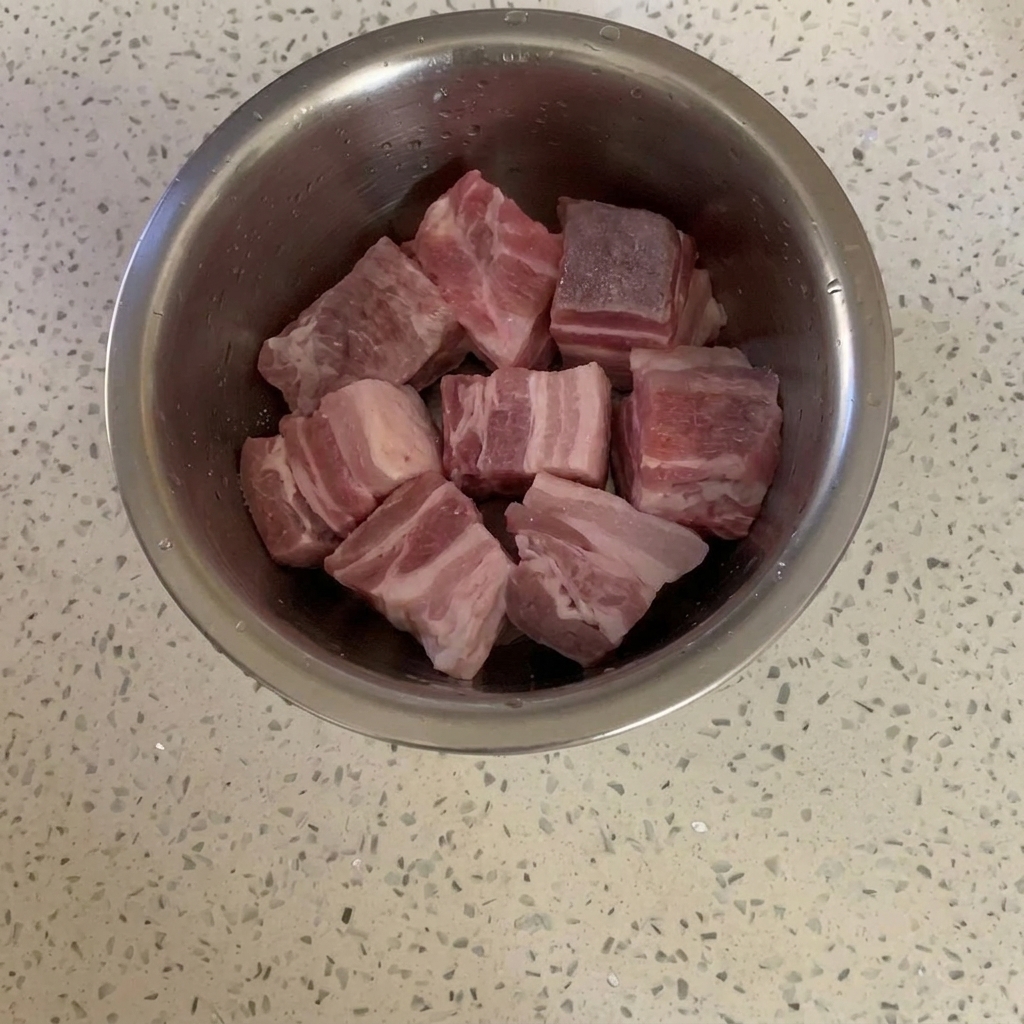 Kawałki boczku w metalowej misce delikatnie posypane cukrem.
