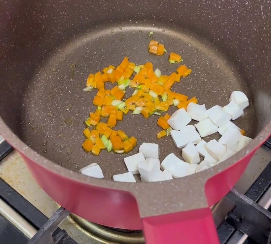 Kostki tofu, usmażona wołowina i podsmażona marchew połączone razem na patelni.