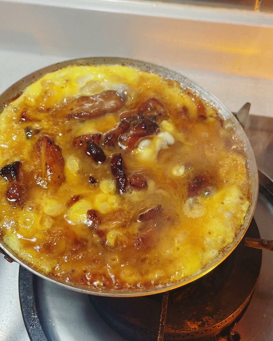 Oyakodon na patelni z jajkami o miękkiej, błyszczącej i półpłynnej konsystencji.
