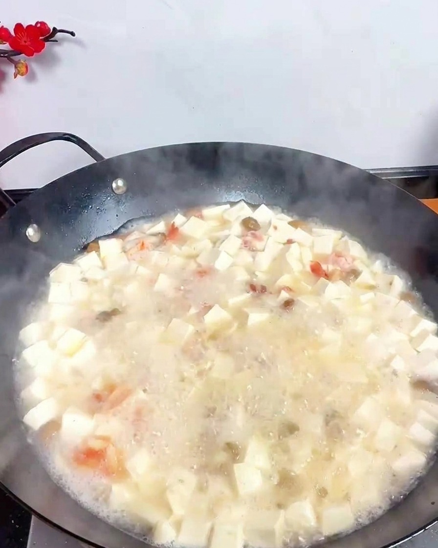 Chochla wlewająca ciemny ocet do bulionu z tofu i owocami morza.