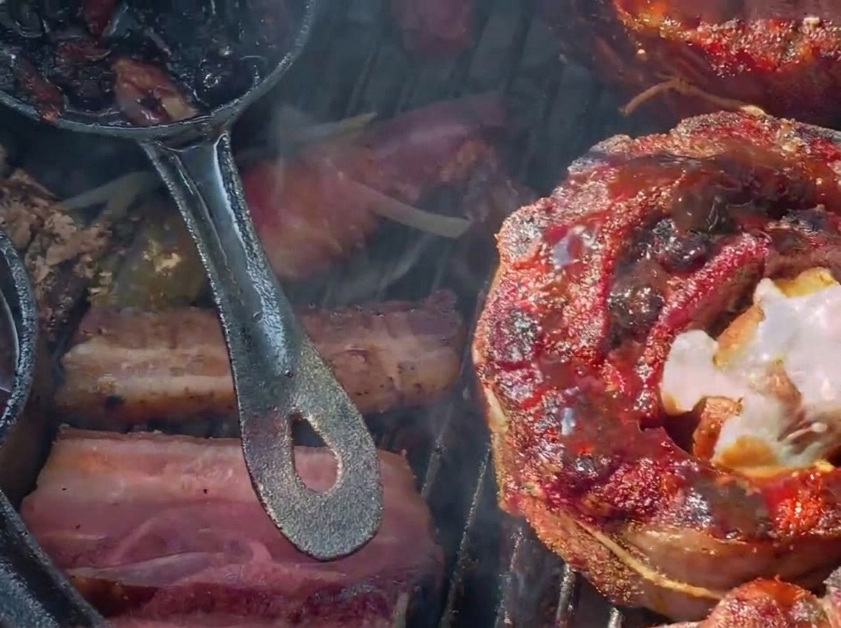 Tarty ser topiący się na ciemnym, polanym sosem borówkowym faszerowanym koszyczku z żeberka na grillu węglowym.