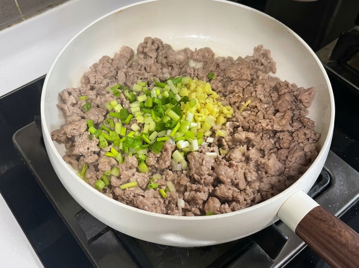 Wieprzowina na patelni mieszana z posiekanymi aromatami i pastami.