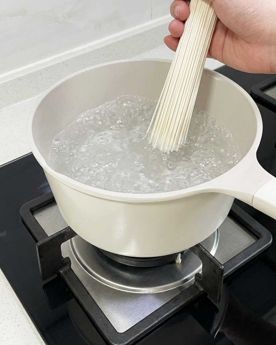 Makaron ramen gotujący się w garnku z wodą.