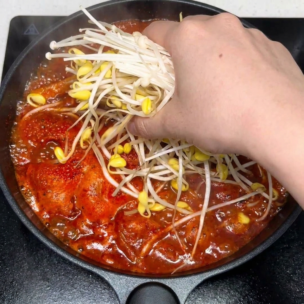 Posiekany czosnek i przyprawy dodawane do pikantnej zupy kimchi z wołowiną.