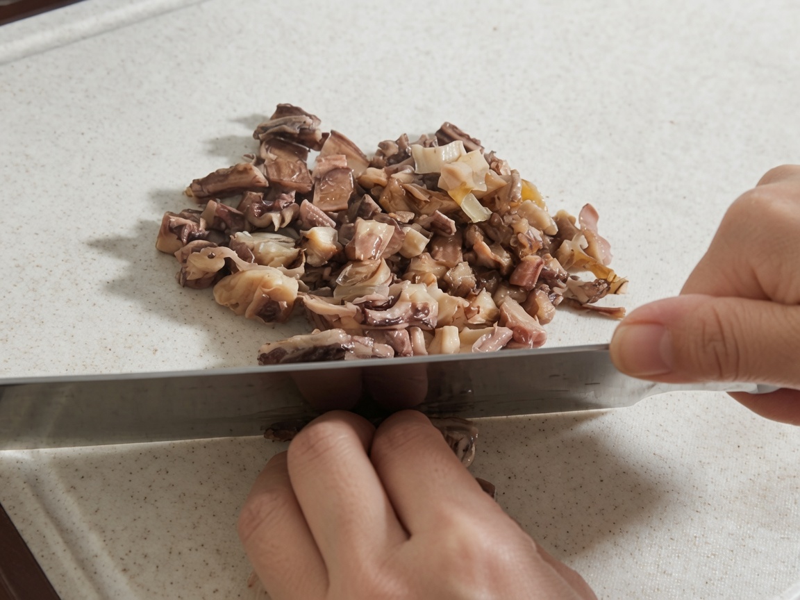 Ręce siekające namoczone grzyby shiitake i kawałki ośmiornicy na białej desce do krojenia.