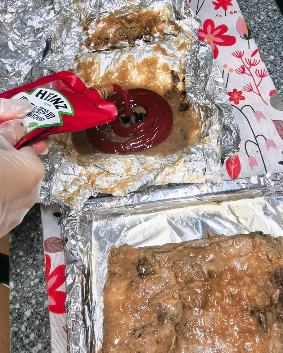 Ketchup wyciskany do miski z sokami z pieczenia i innymi składnikami.