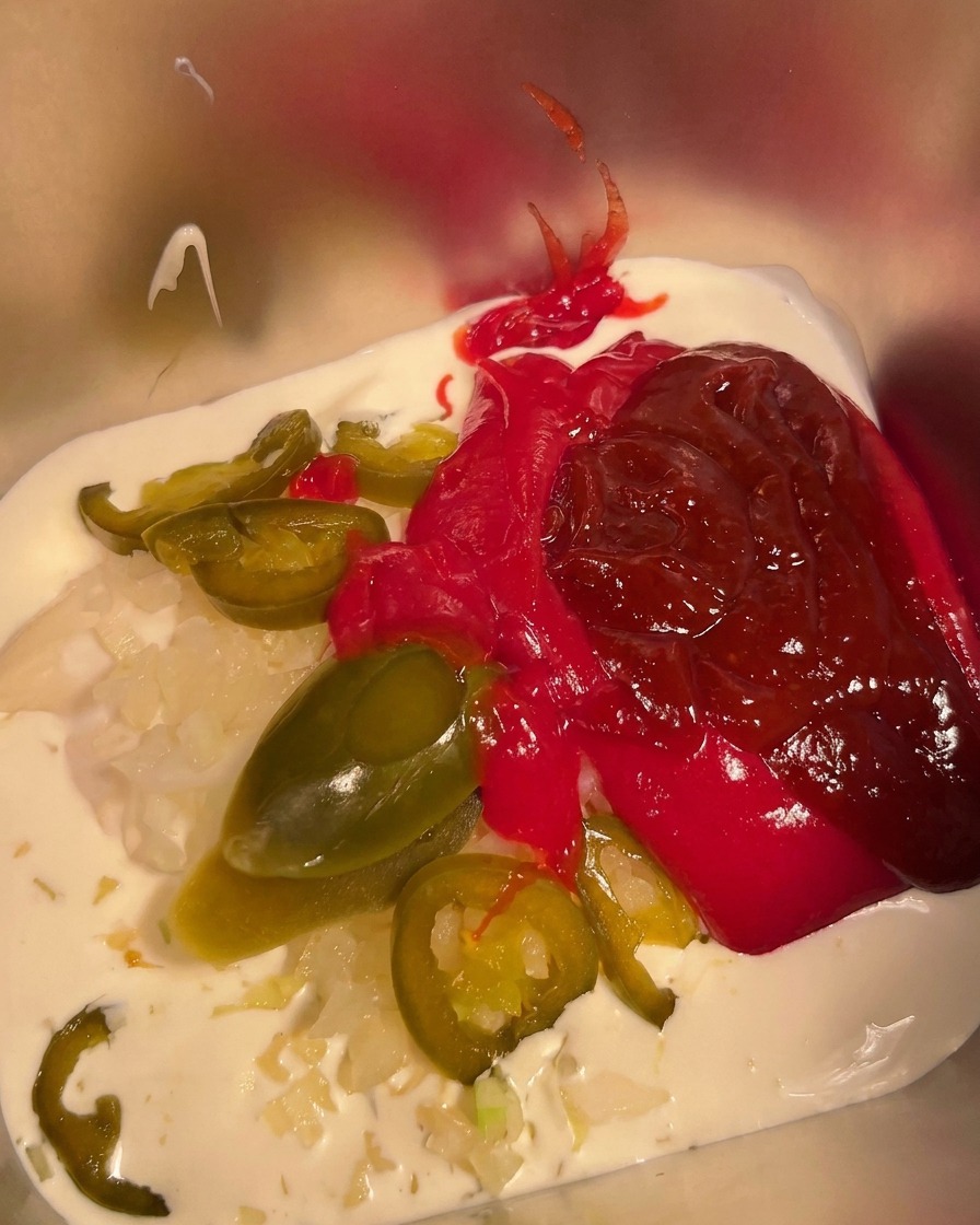 Chili w proszku posypywane na mieszankę w metalowym pojemniku.