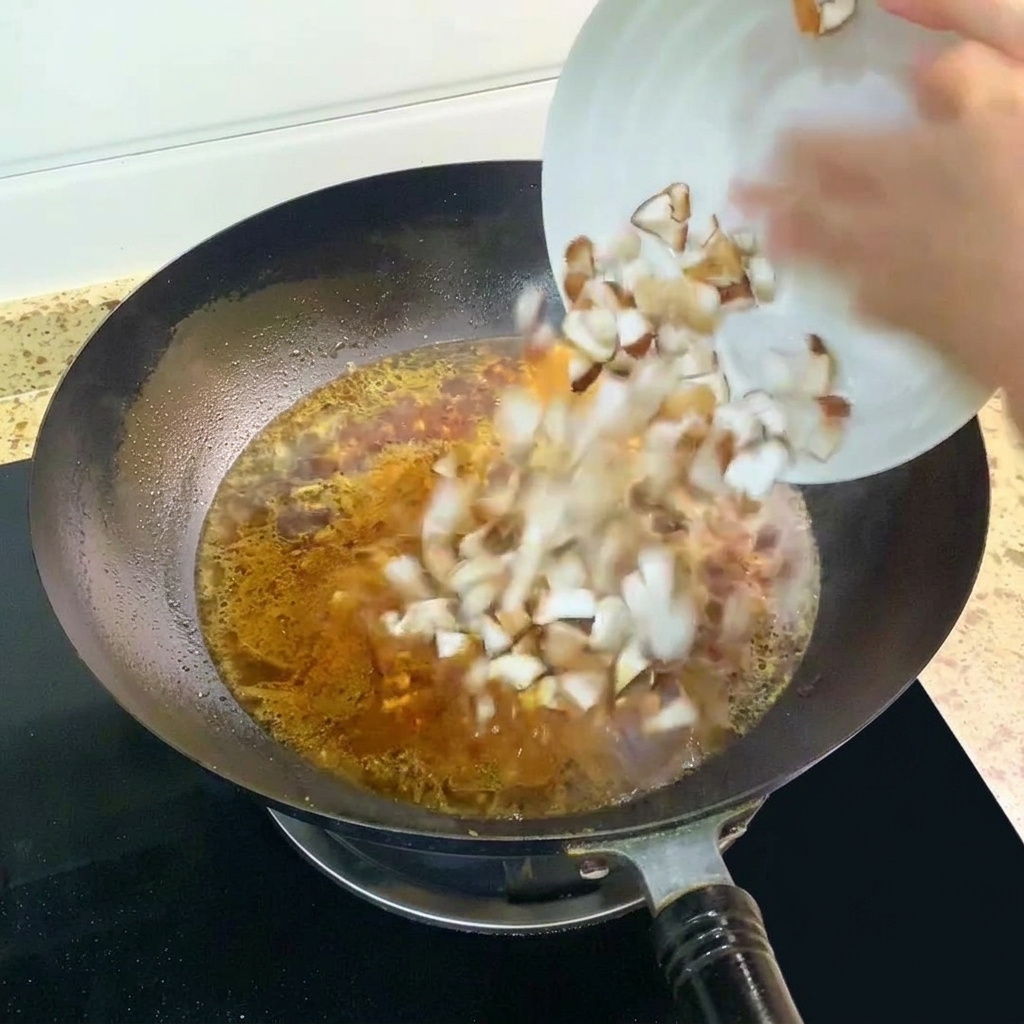 Grzyby shiitake dodawane do wrzącej zupy w woku.