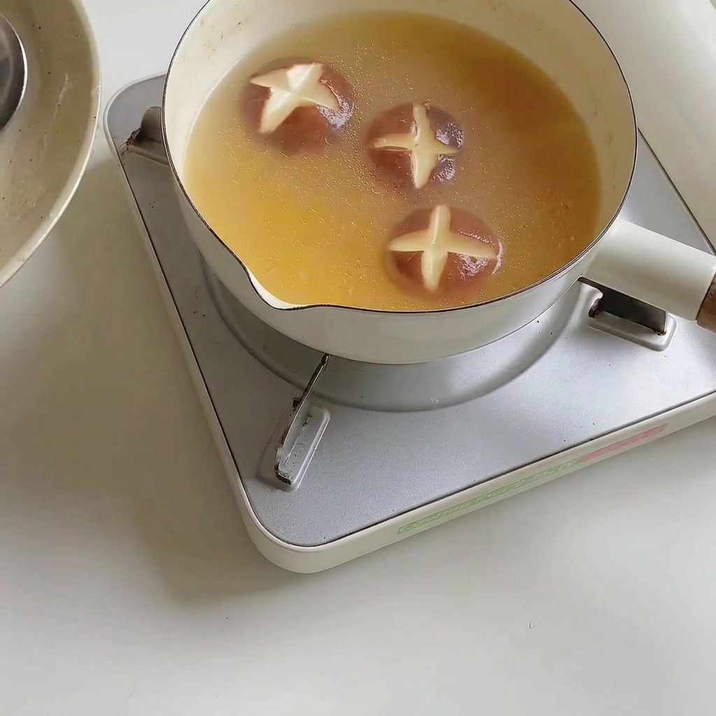 Makaron ramen mięknący we wrzącym bulionie.