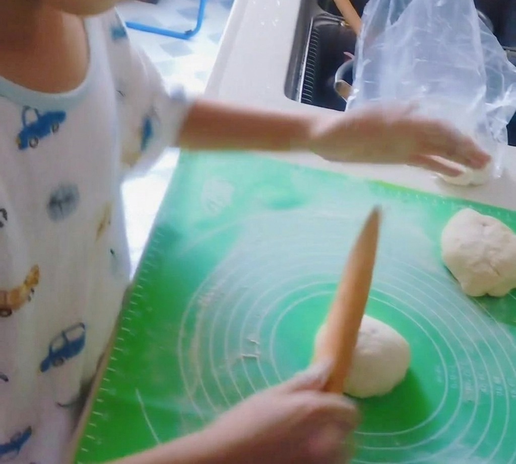 Drewniany wałek spłaszczający kulę ciasta na pizzę w okrągły spód.