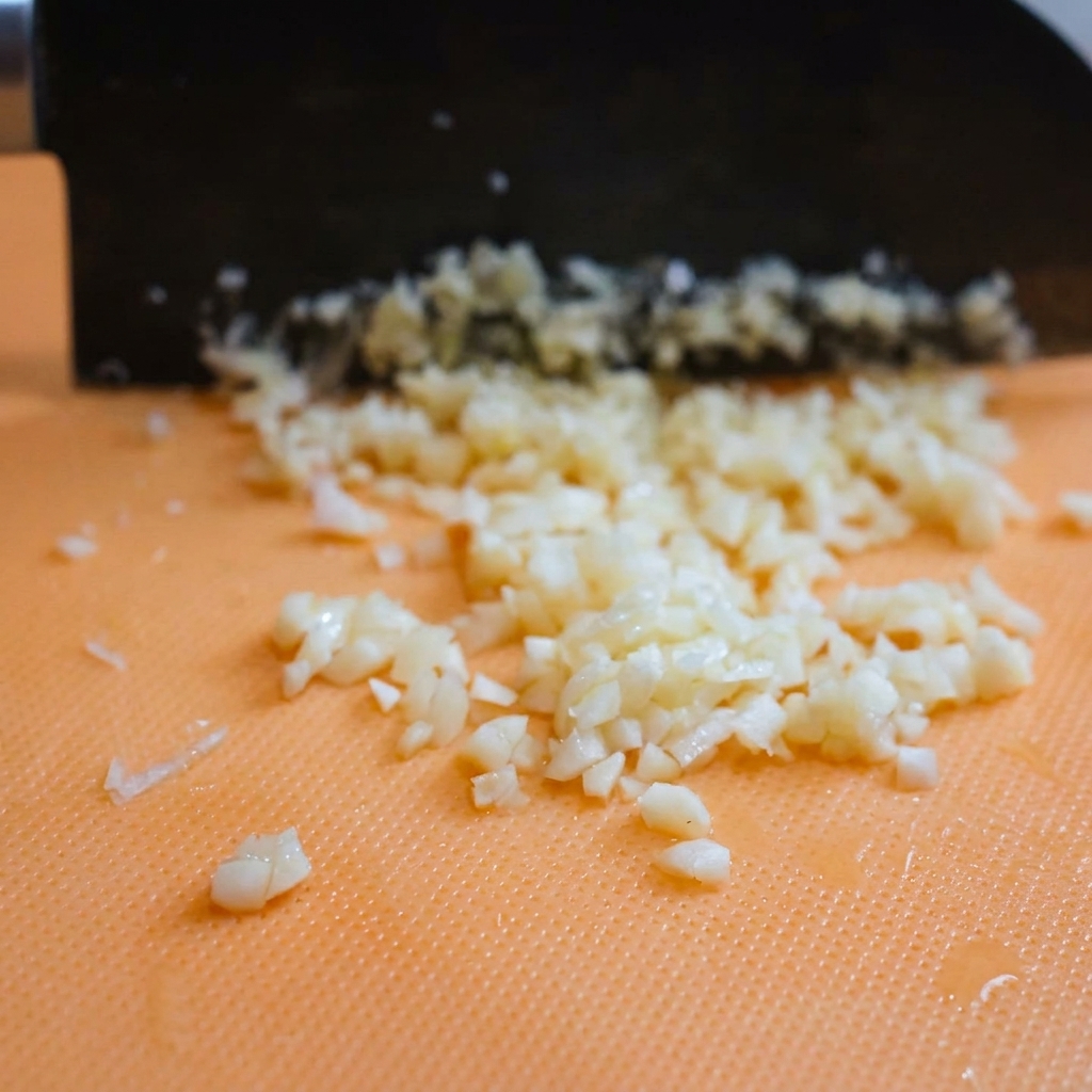 Kopczyki świeżo startego parmezanu leżące na desce do krojenia.