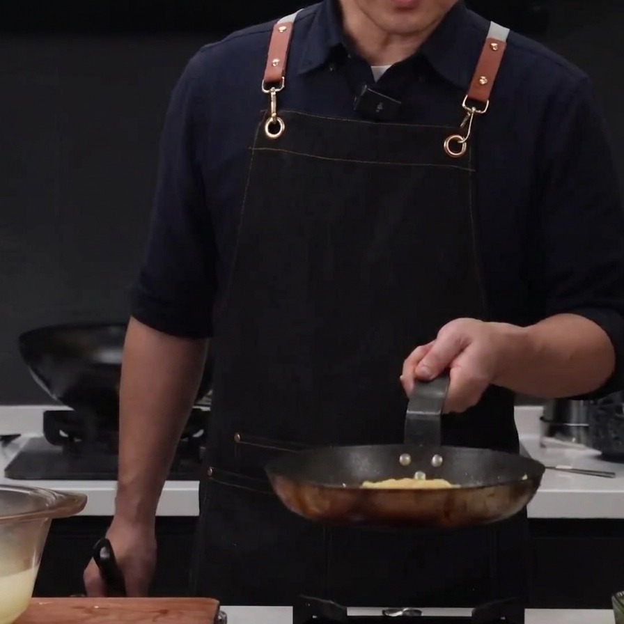 Woda z gotowania makaronu wlewana do kurczaka i spaghetti na patelni, aby rozluźnić teksturę.