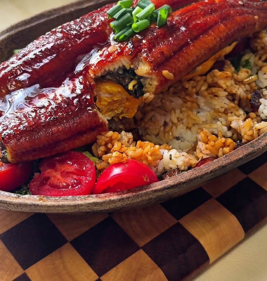 Zbliżenie na gęsty sos teriyaki z cebulą nakładany łyżką na ryż.