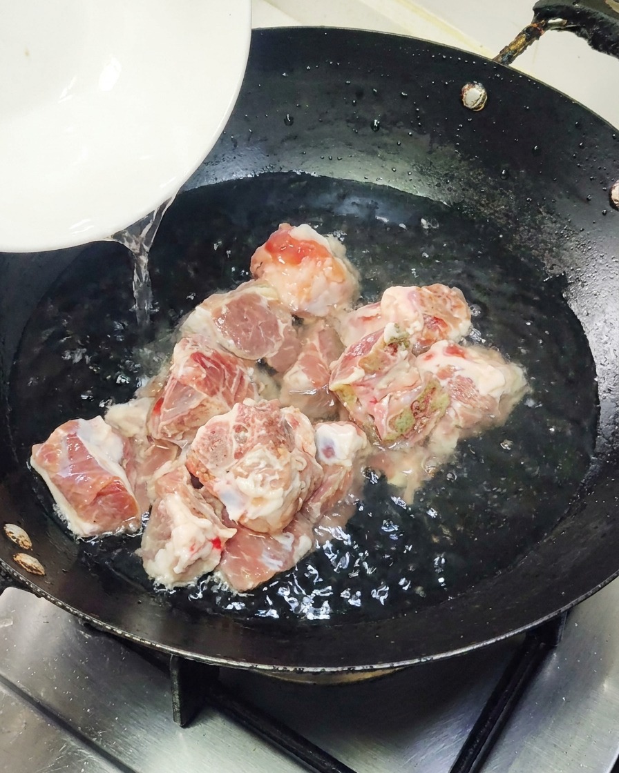 Kawałek pakowanego grillowanego węgorza umieszczany na gorącej patelni.