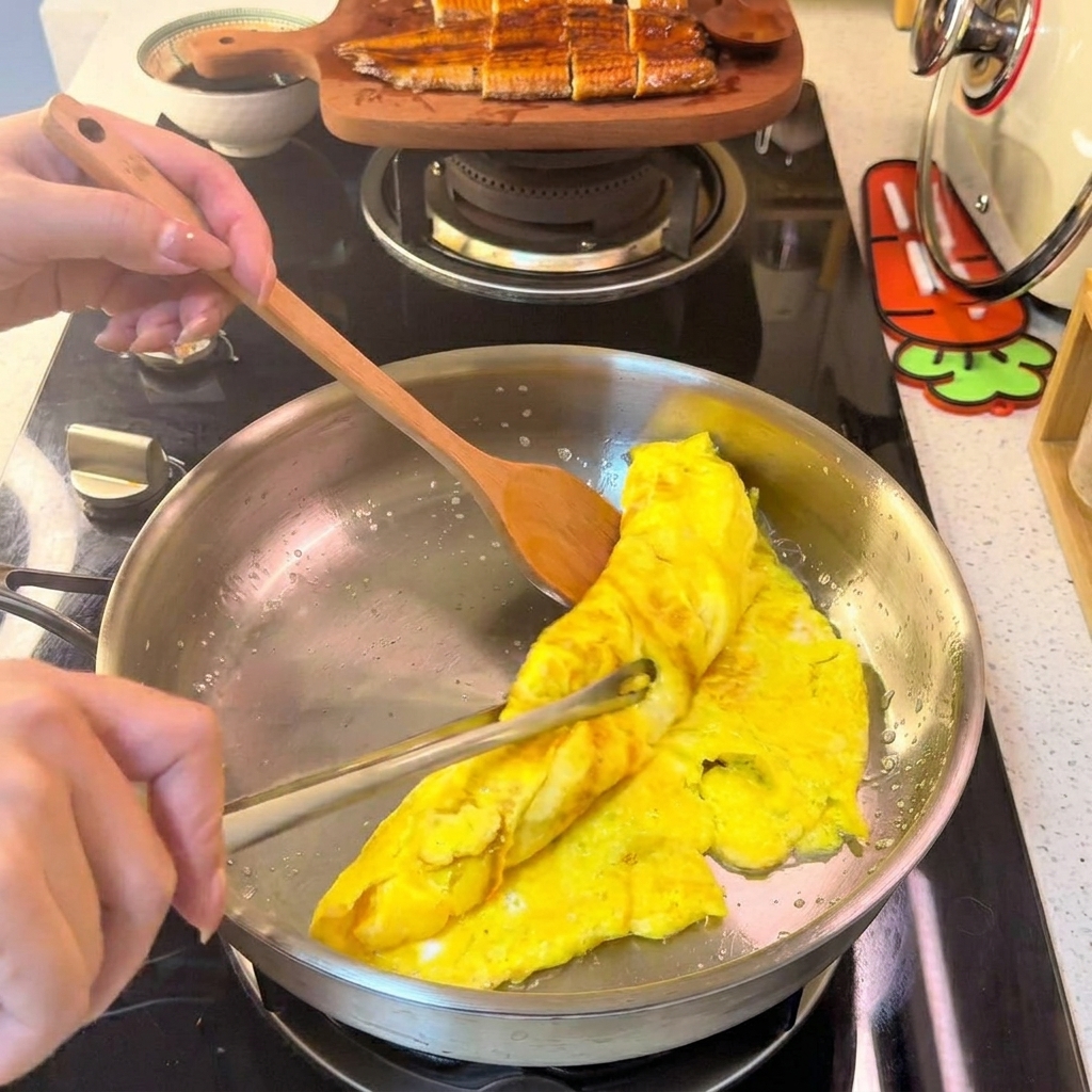 Zwinięty omlet jajeczny krojony na cienkie, równe paski na białym talerzu.