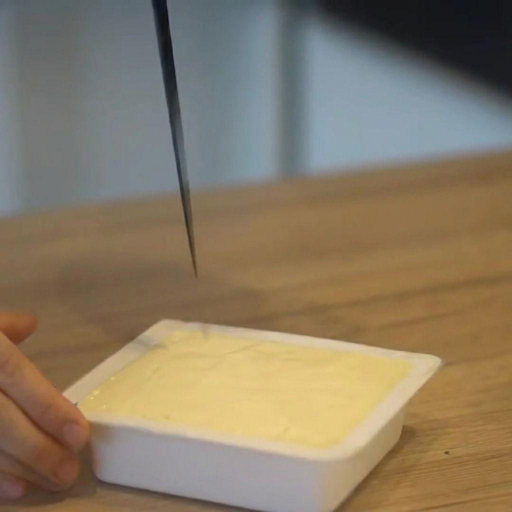 Tofu krojone w kostkę bezpośrednio w plastikowym opakowaniu.