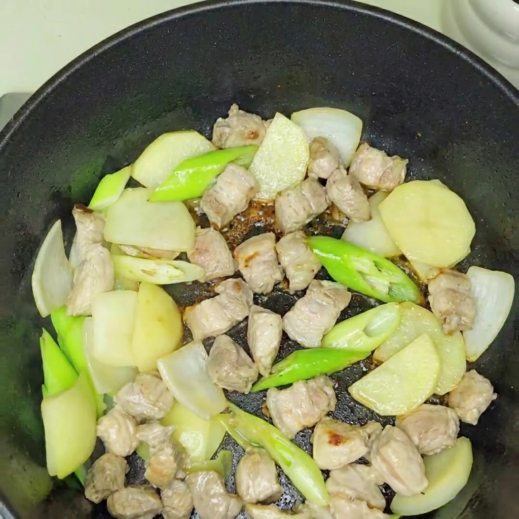 Świeżo dodane kimchi mieszane z podsmażoną bazą wieprzowo-cebulową.