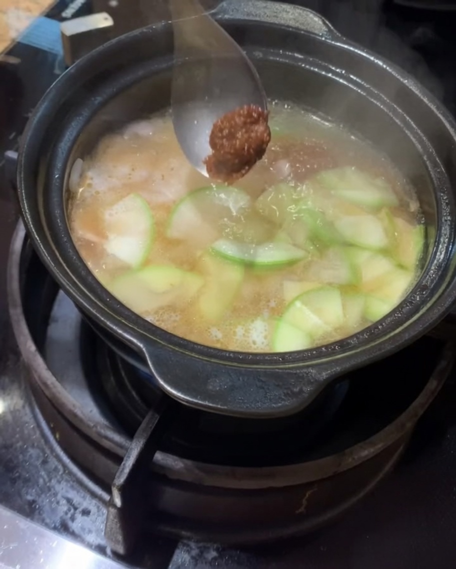 Koreańska pasta sojowa i pasta chili dodawane do gotującego się wywaru.