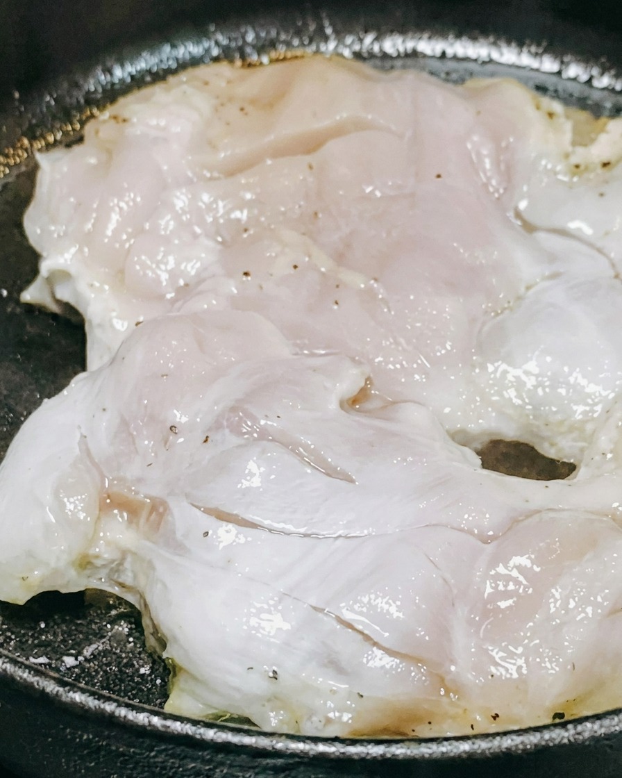 Sos teriyaki i białe wino wlewane na kawałki kurczaka smażące się na patelni.