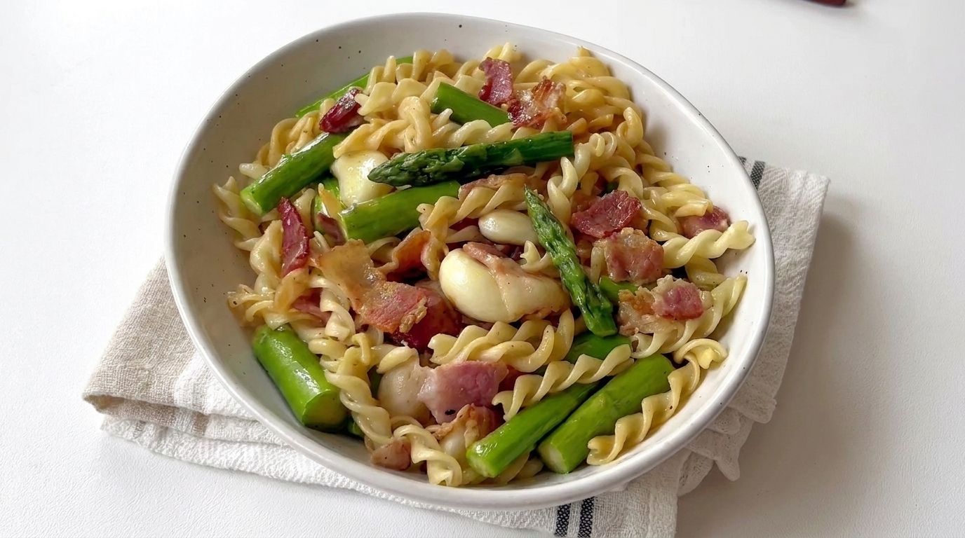 Tętniąca życiem miska makaronu fusilli z chrupiącymi szparagami, aromatycznym boczkiem i czosnkiem.