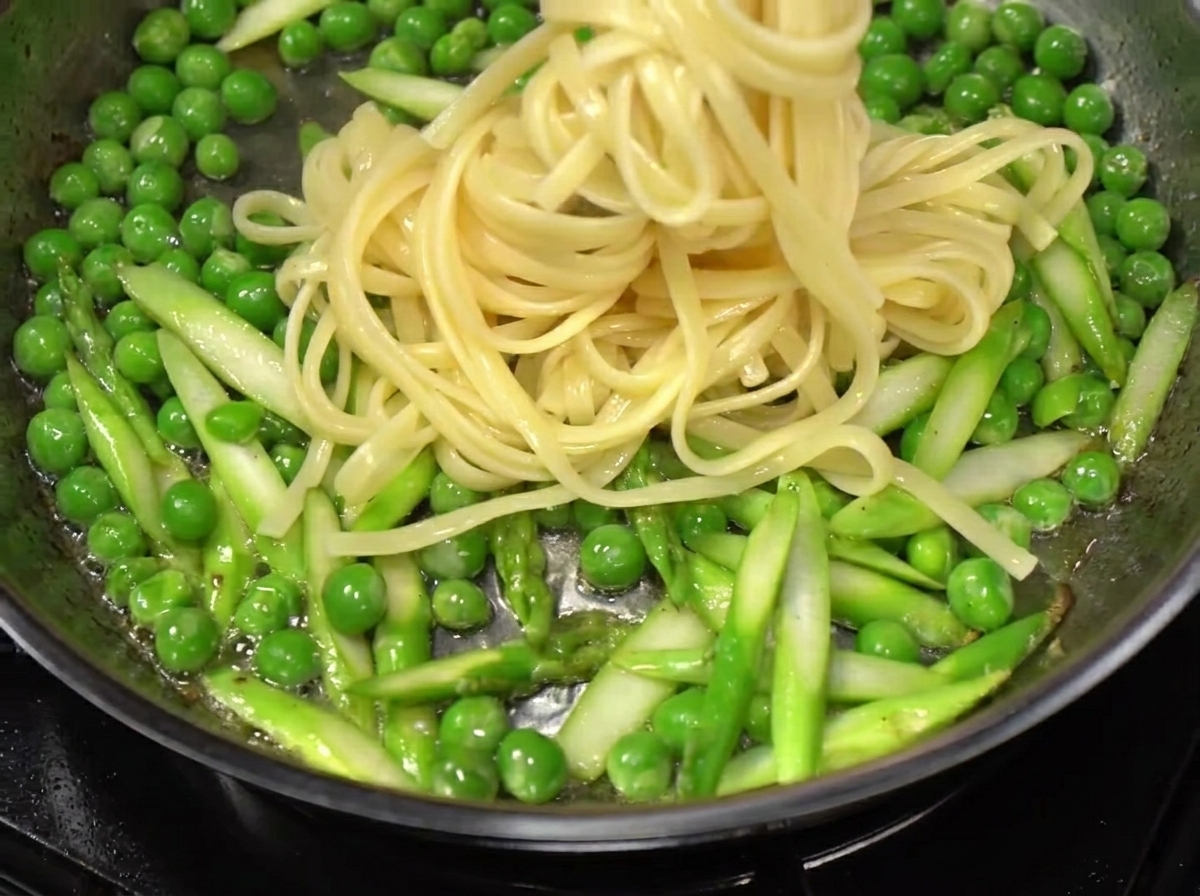 Spaghetti przekładane prosto z wrzątku na patelnię z warzywami i boczkiem.