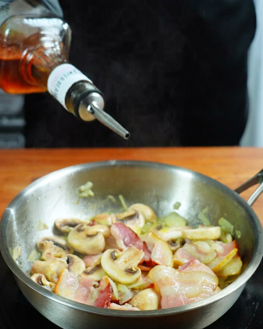 Whisky wlewana na patelnię z boczkiem i pieczarkami.