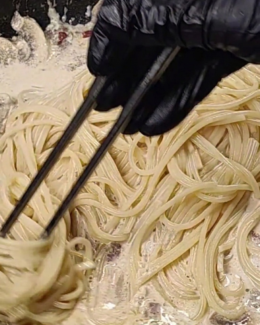 Spaghetti mieszane w kremowym sosie na gorącej patelni.