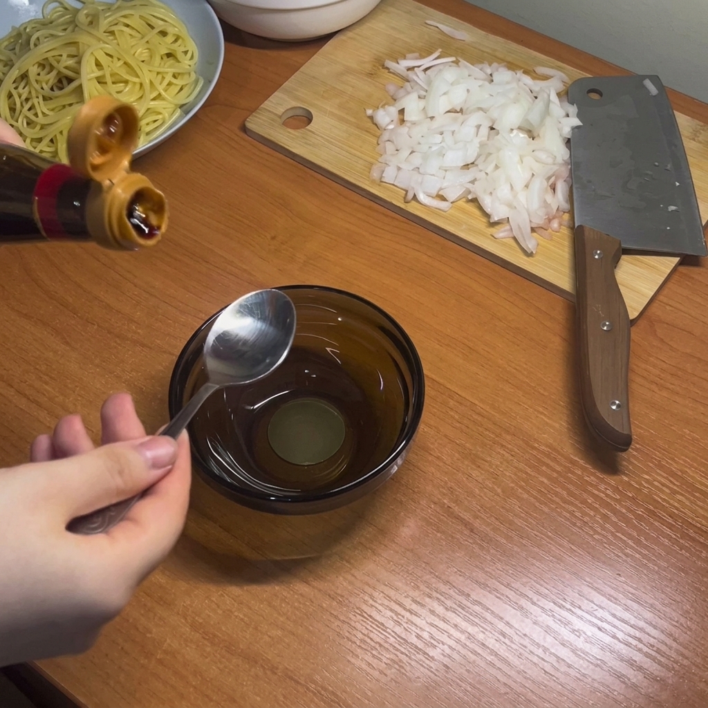 Mieszanie ciemnych płynnych przypraw, takich jak sos sojowy i ostrygowy, w małej szklanej miseczce.