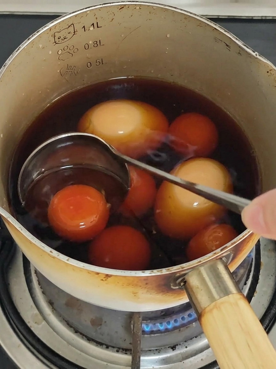 Spaghetti mieszane pałeczkami na patelni, aby pokryć je sosem.