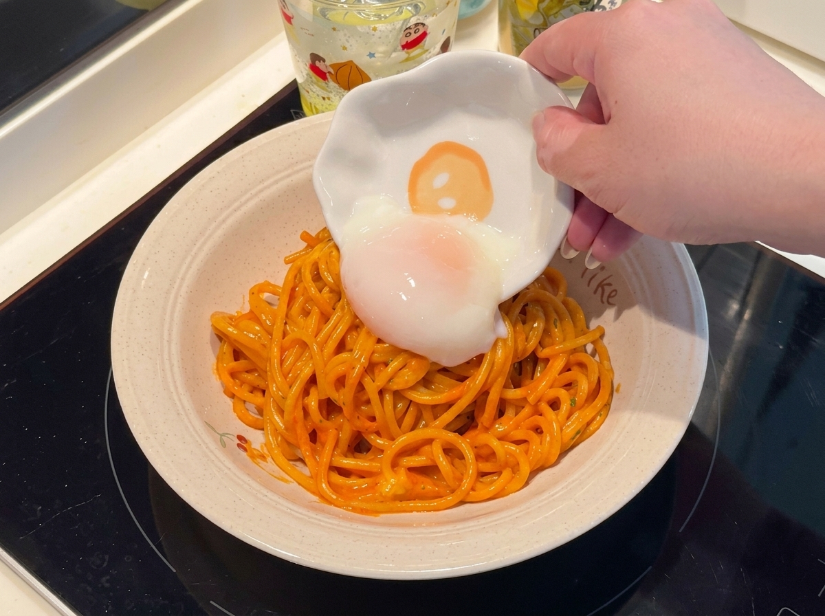Jajko na miękko kładzione na talerzu z pikantnym spaghetti.