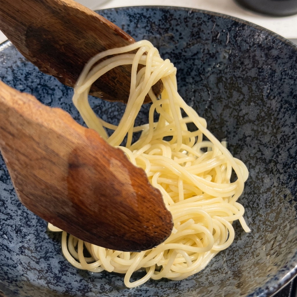 Ugotowany makaron ramen wyjmowany z garnka za pomocą dużej drewnianej łyżki.