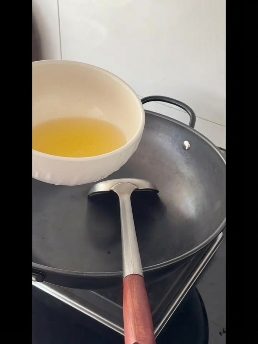 Olej do smażenia wlewany do dużego, pustego woka.