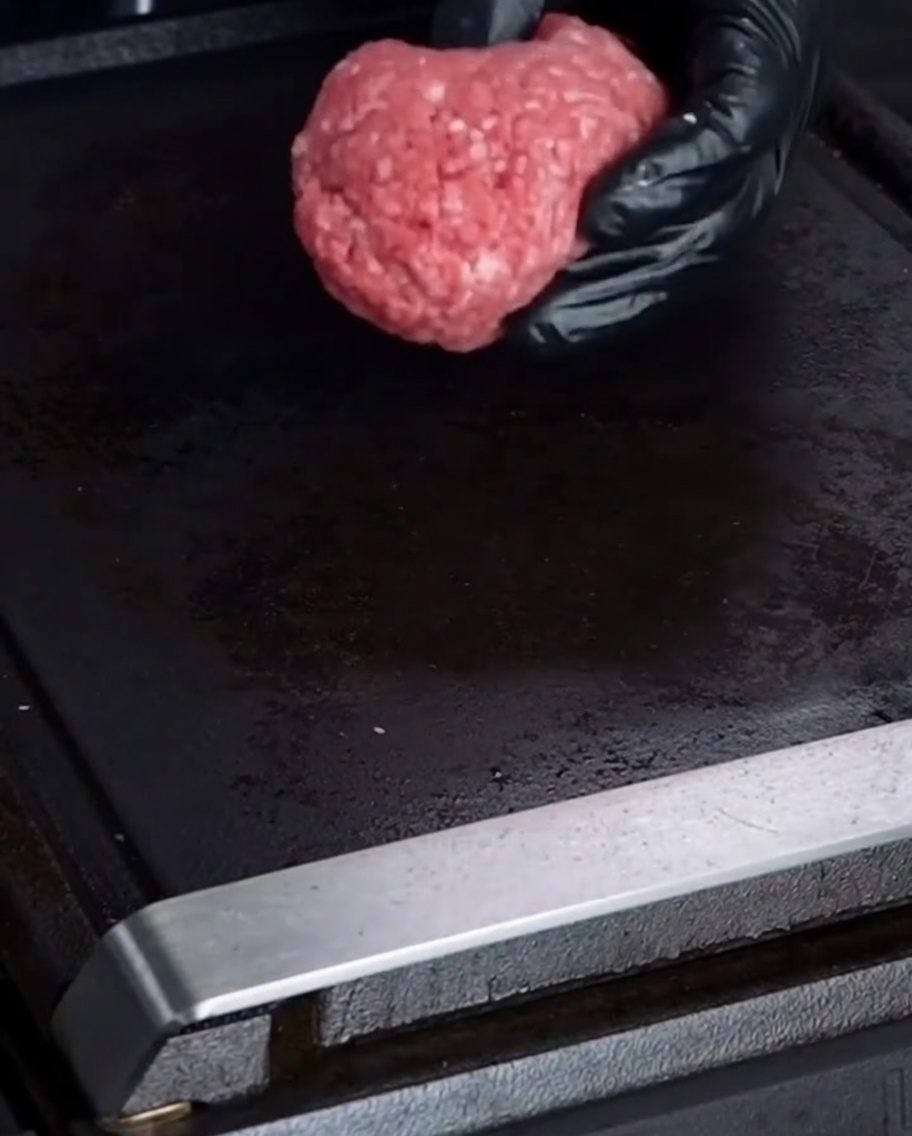 Formowanie kul z wołowiny na gorącym grillu.