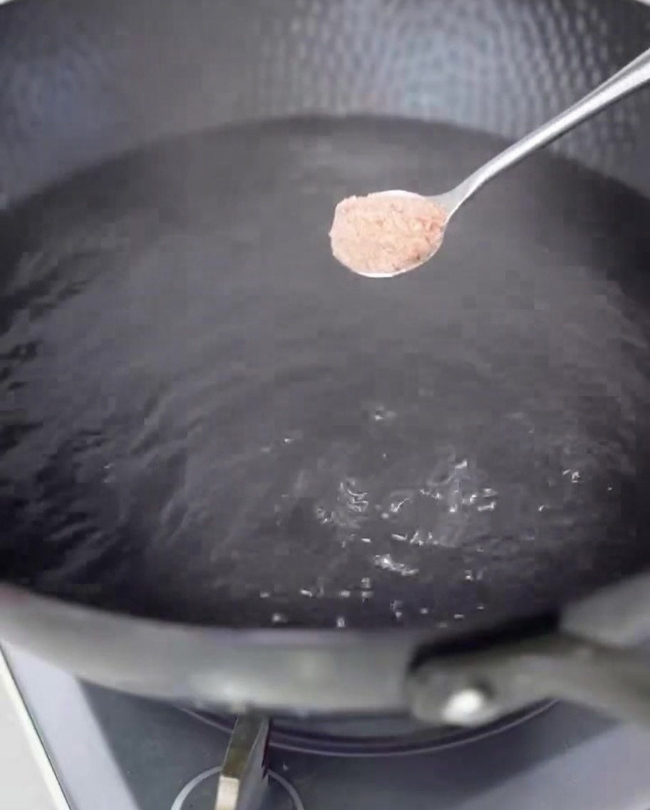 Gotujące się spaghetti w dużym garnku z osoloną wodą.