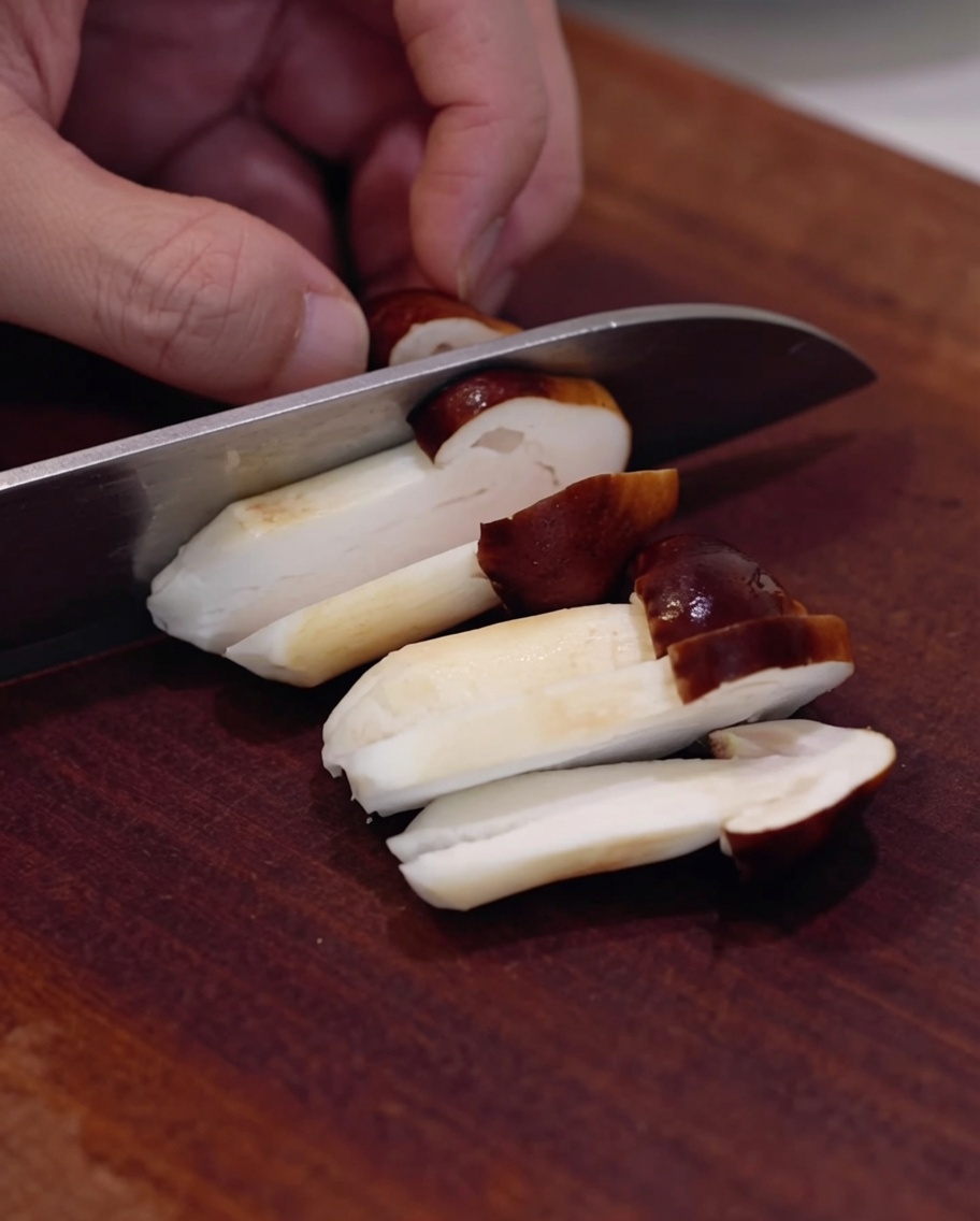 Świeże grzyby shiitake krojone na drewnianej desce.