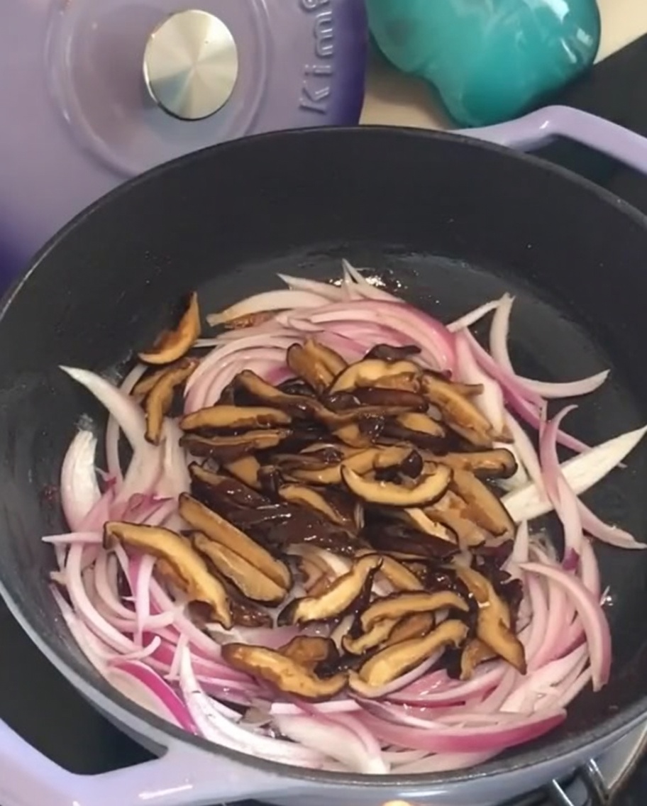 Grzyby shiitake na patelni z podsmażoną cebulą.
