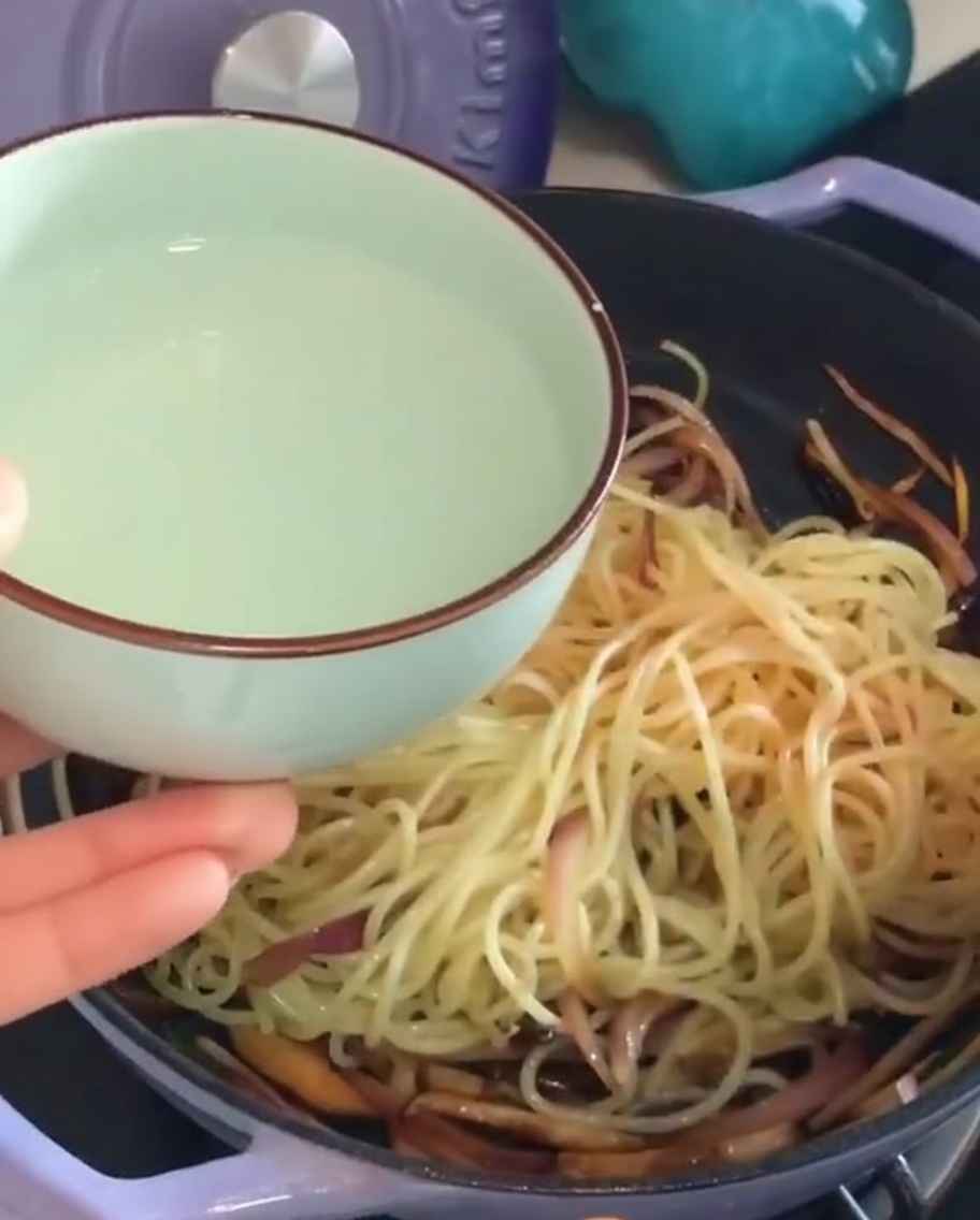 Wlewanie wody z makaronu na patelnię ze spaghetti.