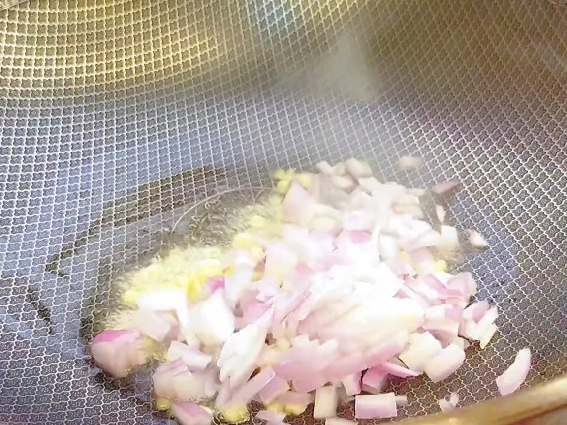 Posiekany czosnek i cebula podsmażane w gorącym woku z olejem.